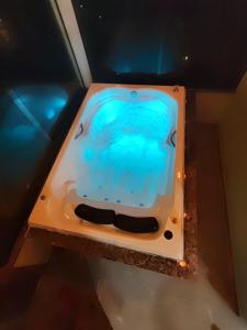 a bath tub with blue water in a room at Cabana Rustica com Hydro, Recanto das Trutas, SC in Bocaina do Sul