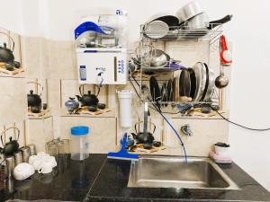 a kitchen with a sink and a shelf with utensils at Shri Ayodhya Homestay in Faizābād