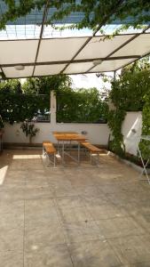 een picknicktafel en twee banken onder een paraplu bij Apartment Gabre Trogir in Trogir