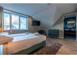 a bedroom with a large bed and a large window at Modern villa in De Cocksdorp near the beach in De Cocksdorp +19 photos