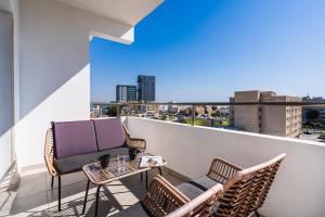 a balcony with two chairs and a table with a view at Phoenix 2-Bedroom Apartment in Larnaca