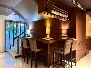 een keuken met een houten bar met krukken bij ลีลาวดี รามอินทรา - Leelawadee Resotel Raminthra 23 in Bangkok