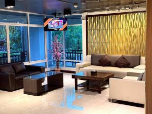 een woonkamer met een bank en een tafel bij ลีลาวดี รามอินทรา - Leelawadee Resotel Raminthra 23 in Bangkok