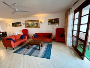 a living room with red couches and a coffee table at Pwani luxe apartment in Mombasa