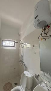 a bathroom with a toilet and a sink and a mirror at Chambre meublée in Dakar