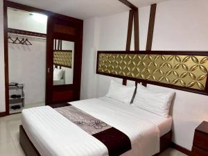 een slaapkamer met een groot bed met witte lakens bij ลีลาวดี รามอินทรา - Leelawadee Resotel Raminthra 23 in Bangkok +53 foto's