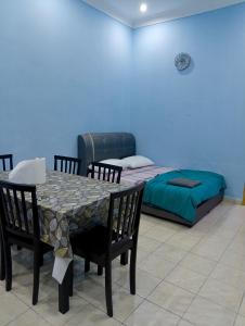 a room with a table and chairs and a bed at Yesh Homestay in Bahau