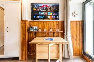 a table in a room with a tv on a wall at MCX Vacation Rental - Belle Vue Les Grandes Murailles, Pet Friendly Apartment just 300 meters from the ski lifts! in Breuil-Cervinia