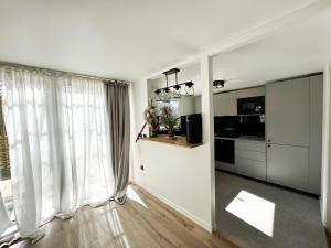 a kitchen with white walls and large windows at Cozy holiday home near the lake, perfect for the family in Bredared