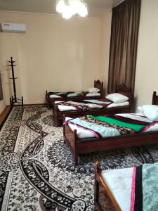 a group of four beds in a room at Qokhna Samarqand in Samarkand