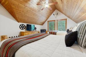 ein Schlafzimmer mit zwei Betten und einer Holzdecke in der Unterkunft Deer Pine Cabin in Bigfork