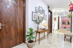 a hallway with a table and a potted plant at FabHotel Hari Residency in Haridwār