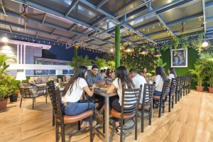 a group of people sitting at a table in a restaurant at FabHotel Hari Residency in Haridwār