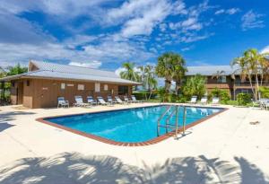 a large swimming pool with chairs and a building at Waterfront Condo by the Marina in Clewiston