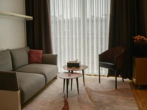 a living room with a couch and a table and a piano at Elios Living Studio Mettewie in Brussels +2 photos
