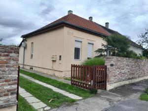 a house with a gate and a brick wall at Relax apartman in Nagykanizsa