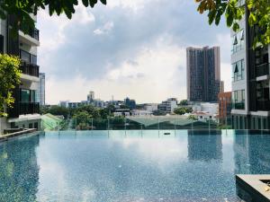 a swimming pool in the middle of a city with buildings at Luxury Two bedrooms Thonglor in Bangkok