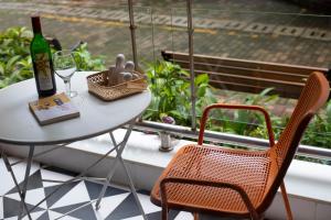 a table and chairs on a balcony with a bottle and a glass at Casa Leo by Leo Homes 2BHK Flat near Anjuna Beach in Anjuna