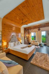 a bedroom with a large bed with a wooden ceiling at SaffronStays JungleBrooke in Pali