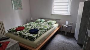 Un dormitorio con una cama con un edredón verde y blanco. en Ferienwohnung an der Sommerliede, en Hohenroda