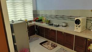 a kitchen with a counter and a microwave in it at Homestay Annur Barakah in Kampung Raja