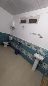 a bathroom with a sink and a toilet at Accomoon River Side Cottages in Dirang Dzong