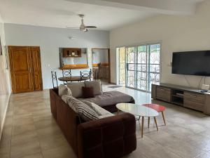 a living room with a couch and a flat screen tv at Villa Du Soleil Ngaparou in Ngaparou