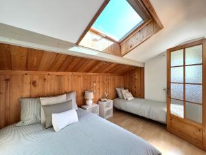 a bedroom with two beds and a skylight at Appartement Champêtre - Terrasse, Vue & Parking by AlpenlySallanches in Domancy