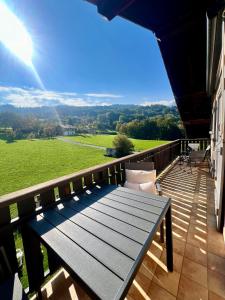 a wooden bench on the balcony of a house at Appartement Champêtre - Terrasse, Vue & Parking by AlpenlySallanches in Domancy
