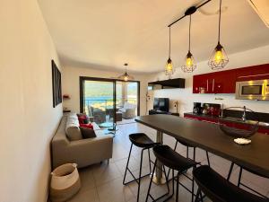 a kitchen and living room with a table and chairs at Appartement neuf tout confort en bord de mer in Propriano