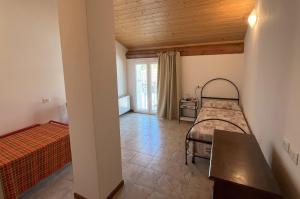 a bedroom with two beds and a wooden ceiling at Agriturismo Cascina Mezzulli in Ostiano
