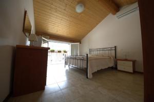 a bedroom with a bed and a wooden ceiling at Agriturismo Cascina Mezzulli in Ostiano