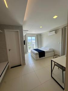 1 dormitorio con 1 cama y puerta a un balcón en Home Studio, en Sobral 11 fotos más