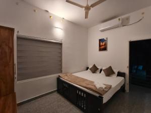 a bedroom with a large bed with a window at Whitefort Family Villa Alleppy-Homestay in Alleppey