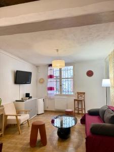 a living room with a couch and a table at Le Cocon D'Alembert in Arles