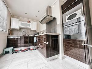 a kitchen with wooden cabinets and stainless steel appliances at Panorama Méditerranéen Vue exceptionnelle sur le Mont Caume et Faron 3 chambres 69m2 in Toulon