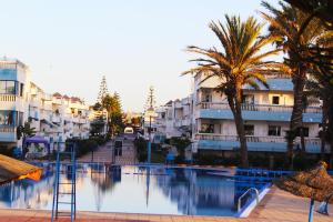 a view of a swimming pool with palm trees and buildings at Palm beach in Mansouria in Ben Slimane