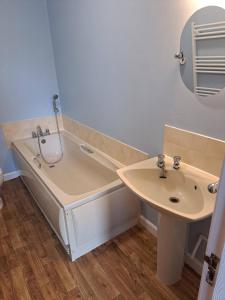 un baño con bañera y lavabo en Skegness, peaceful, bungalow, king bed, parking, en Winthorpe