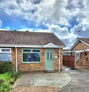 una casa de ladrillo con una puerta verde en una entrada en Skegness, peaceful, bungalow, king bed, parking, en Winthorpe