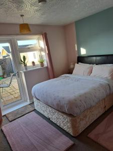Un dormitorio con una cama grande y una ventana. en Skegness, peaceful, bungalow, king bed, parking, en Winthorpe