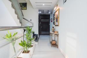 a hallway with potted plants and a black door at FabHotel Jalsa DLX in Bhopal