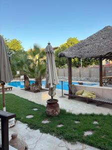 - une terrasse avec un parasol à côté de la piscine dans l'établissement VESTA - El Gouna Residence, à Hurghada