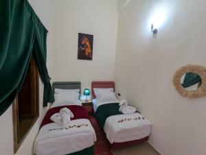 two beds in a room with towels on them at Dar BERNANI in Rabat +16 photos