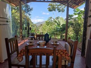 a dining room with a table and chairs with a view at Casa Ipê Rosa in Itabira