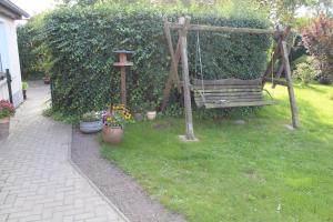 a swing in a yard with some plants and flowers at Ferienwohnung "Feldblick" Schuhmacher in Gützkow