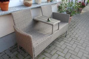 a wicker chair with a table on a patio at Ferienwohnung "Feldblick" Schuhmacher in Gützkow