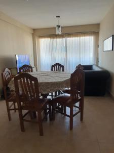 een woonkamer met een tafel, stoelen en een bank bij Edificio Junin in Salta