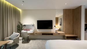 a hotel room with a bed and a flat screen tv at منازل صوان للوحدات السكنية in Al Shafa