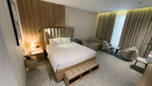 a hotel room with a large bed and a chair at منازل صوان للوحدات السكنية in Al Shafa