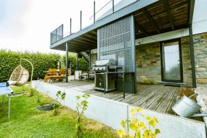 un patio trasero con una parrilla en una terraza de madera en Terrier Ovifat - Nature Jacuzzi & Sauna, en Ovifat